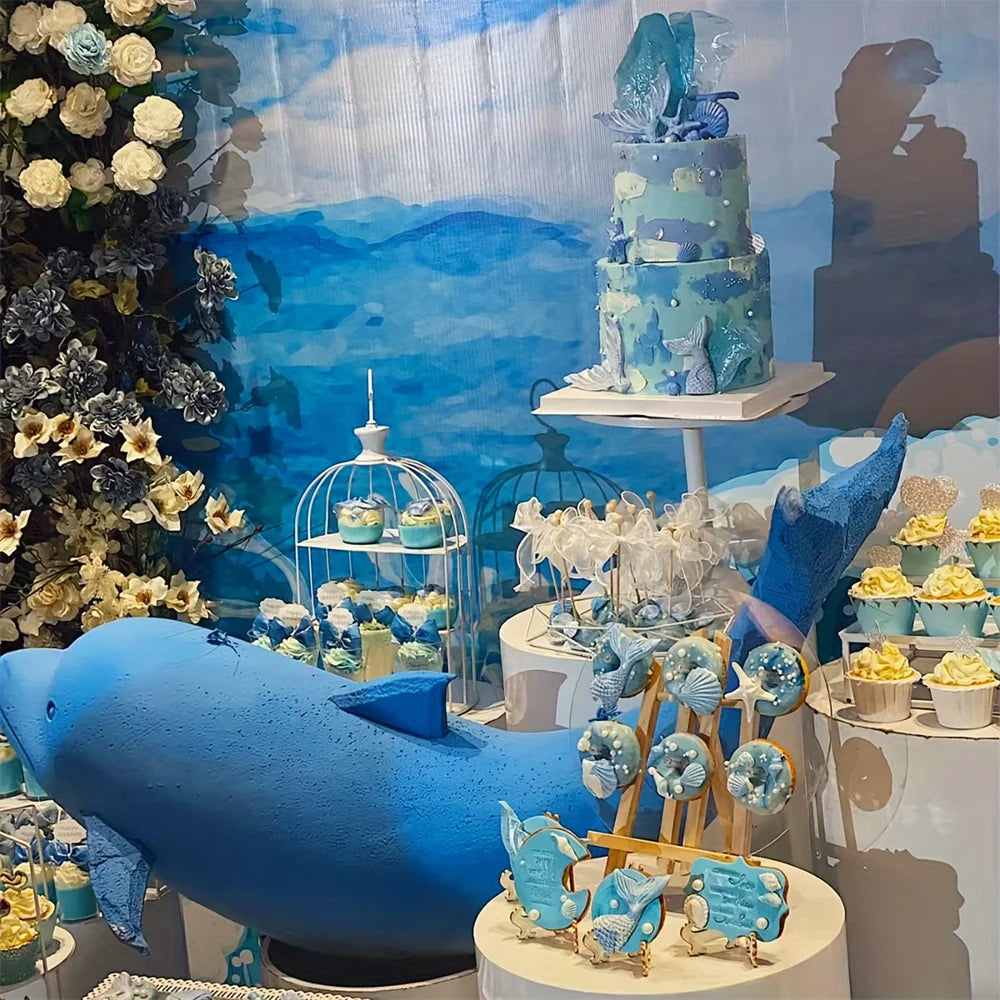 A silicone baking mold set featuring blue and teal ocean-themed shapes, including a large fish and various decorative molds.