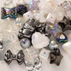 A collection of iridescent and clear acrylic bow and flower beads in various shapes and colors for DIY jewelry making