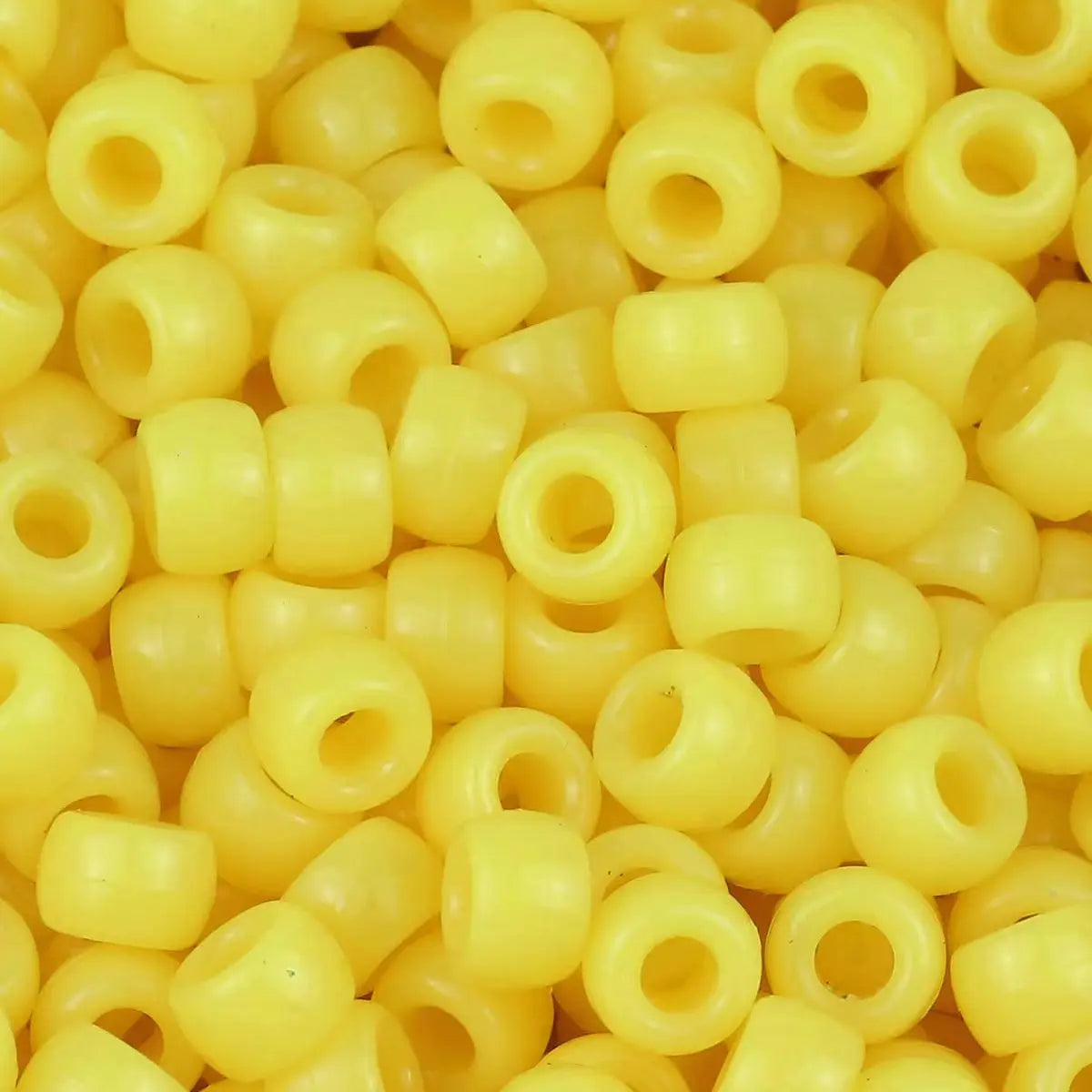 A close-up view of small yellow pony beads for jewelry making and crafts.