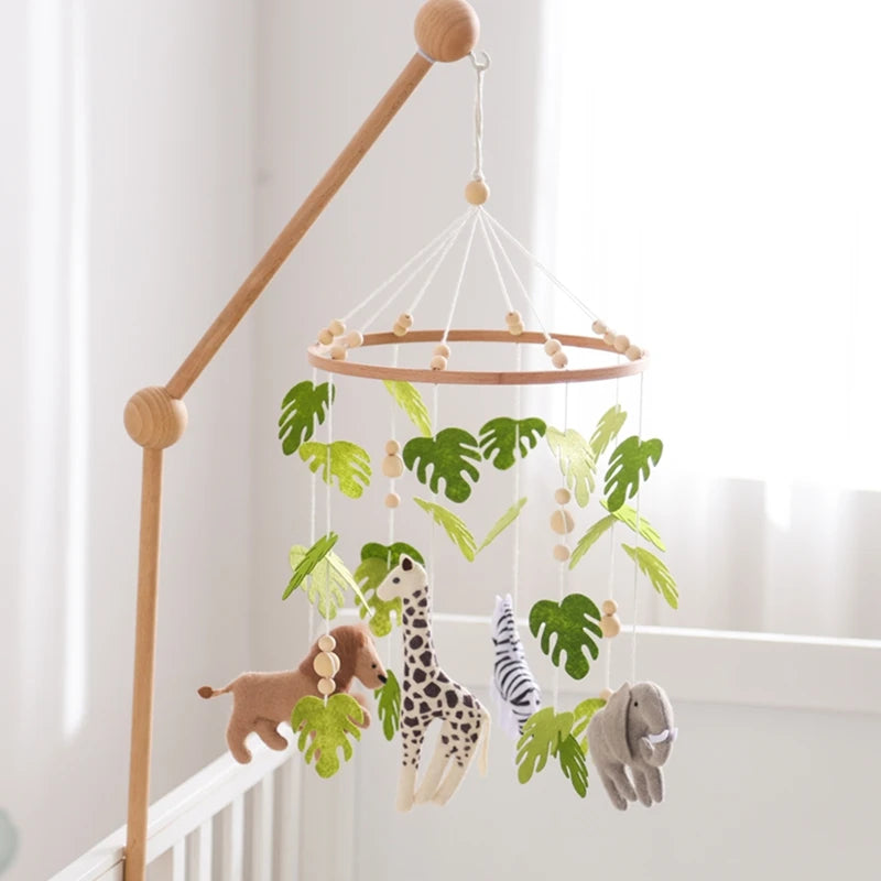 Wooden felt forest animal crib mobile featuring various animals like a giraffe and elephant hanging from a wooden rod.