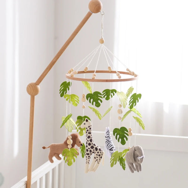 Wooden felt forest animal crib mobile featuring various animals like a giraffe and elephant hanging from a wooden rod.