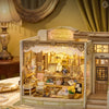 A detailed wooden miniature dollhouse kit displayed on a table, illuminated by warm ambient lighting.
