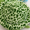 A round, green and white patterned plush toy resembling a leopard print turtle