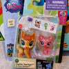 A clear plastic package containing three small animal figures, including a fawn and two feline-like animals.