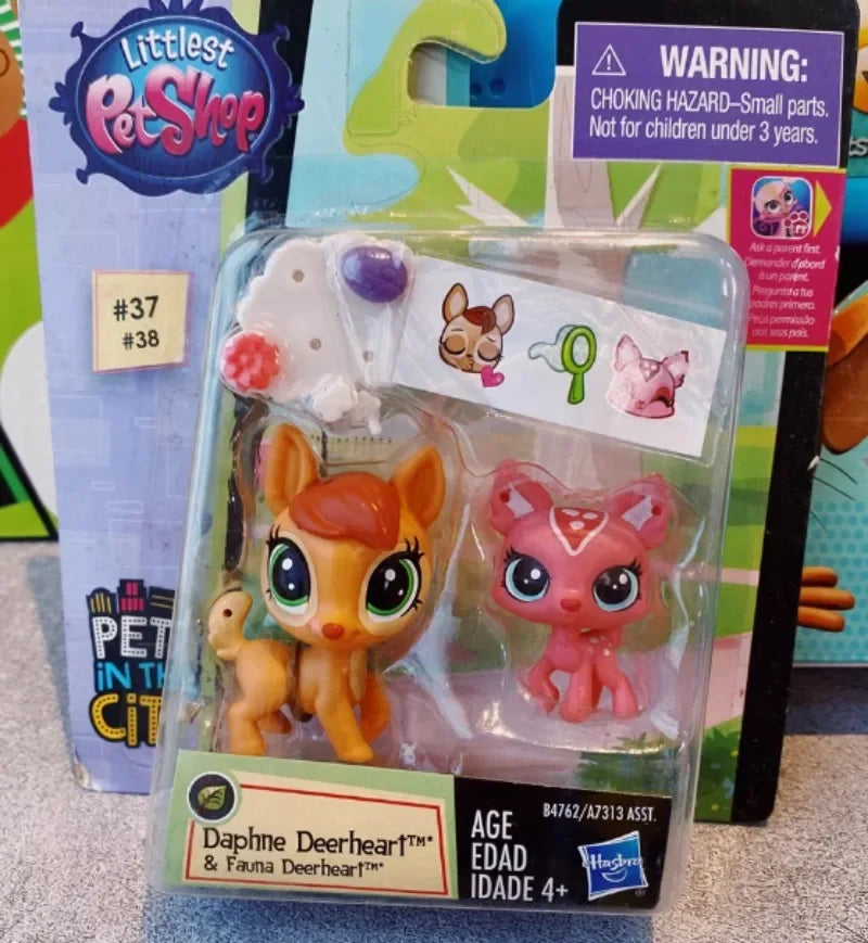 A clear plastic package containing three small animal figures, including a fawn and two feline-like animals.