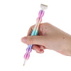 A hand holds a precision diamond painting pen with a gradient pink and blue body and a white tip.