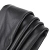 A close-up of premium black cowhide leather with a lychee texture, folded and draped.