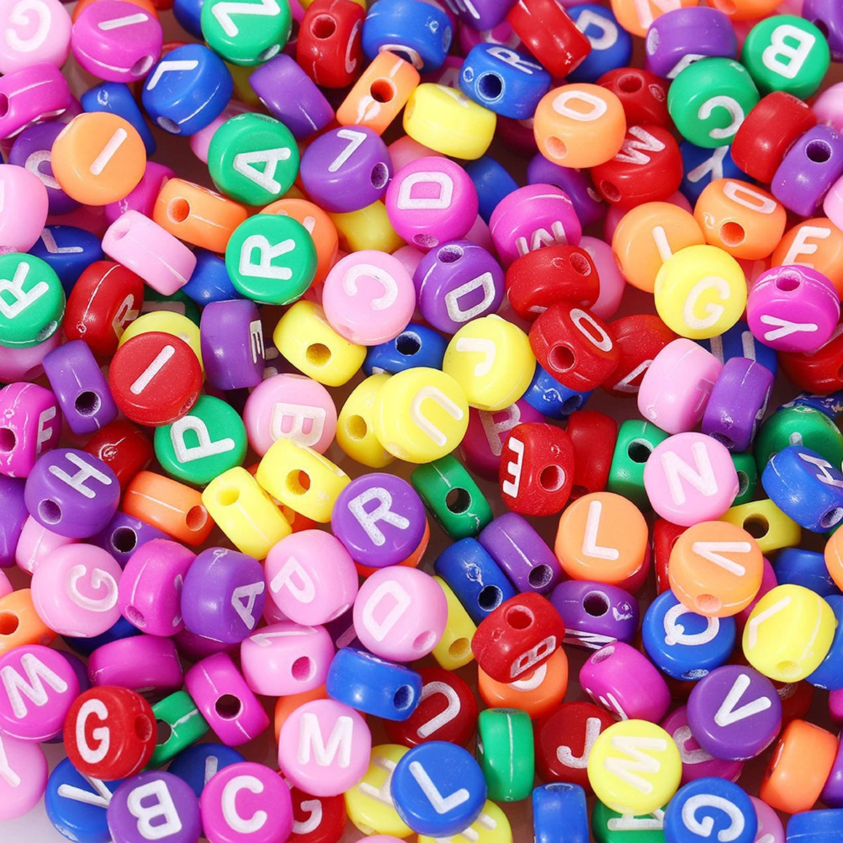 A close-up shot of numerous round acrylic alphabet beads in various colors like red, purple, green, and yellow.