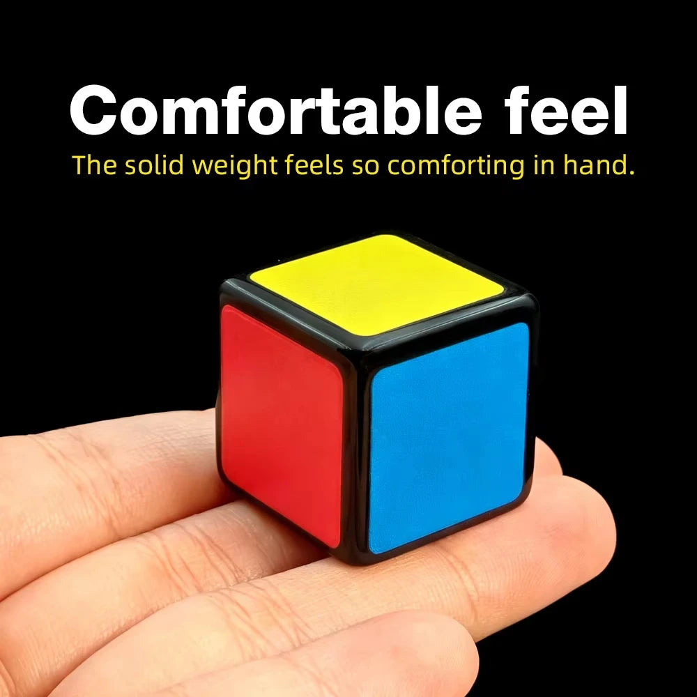 A hand holds a small, colorful cube puzzle with red, blue, and yellow faces.