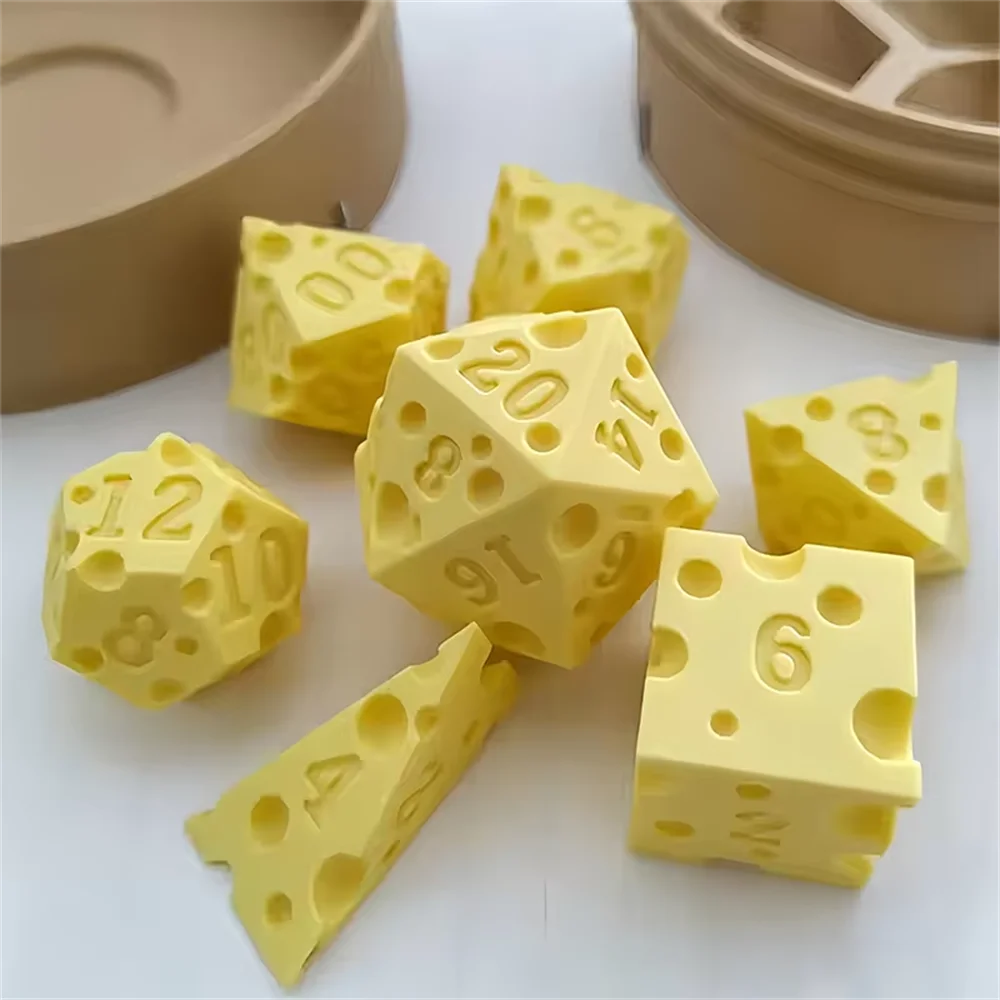 Yellow cheese dice set with various numbered cubes and a carrying case on a white surface