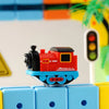 A red and black magnetic train engine sits on blue building blocks.