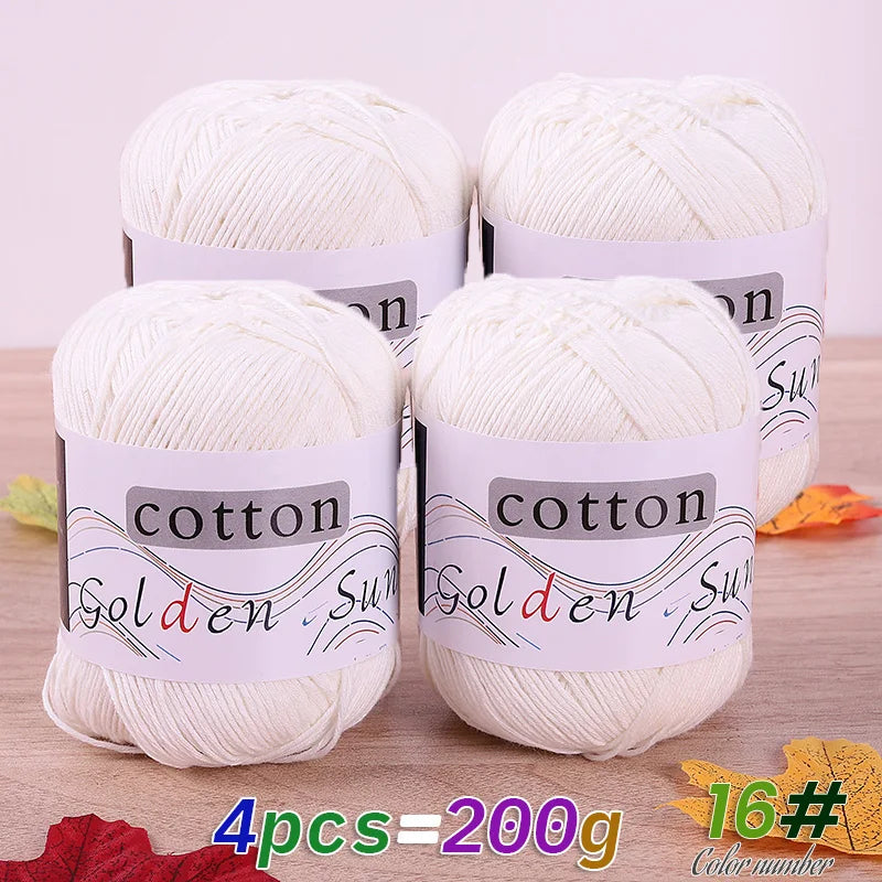 Four balls of white cotton knitting yarn for crochet and handmade projects