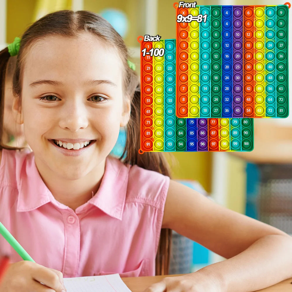 A smiling girl is shown next to a colorful multiplication pop-it math fidget toy chart.