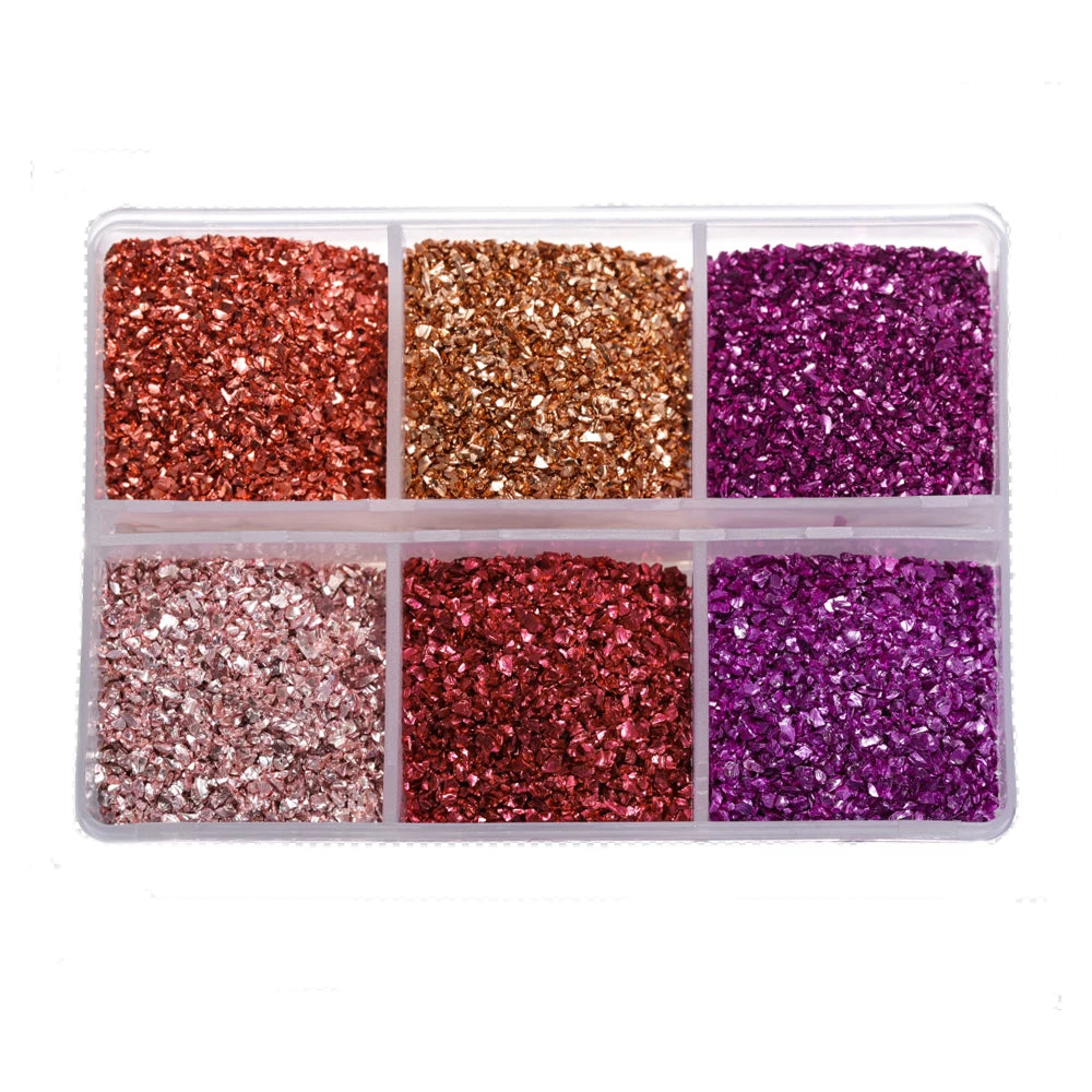A clear plastic tray containing four compartments of glitter in shades of copper, gold, magenta, and purple.