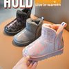 A hand holds a pink winter snow boot with a fluffy faux fur lining and a non-slip sole.