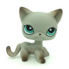 A small, gray Littlest Pet Shop style cat figure with large green eyes standing on a white background.
