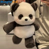 A white and black panda stuffed animal is being held up against a light background.