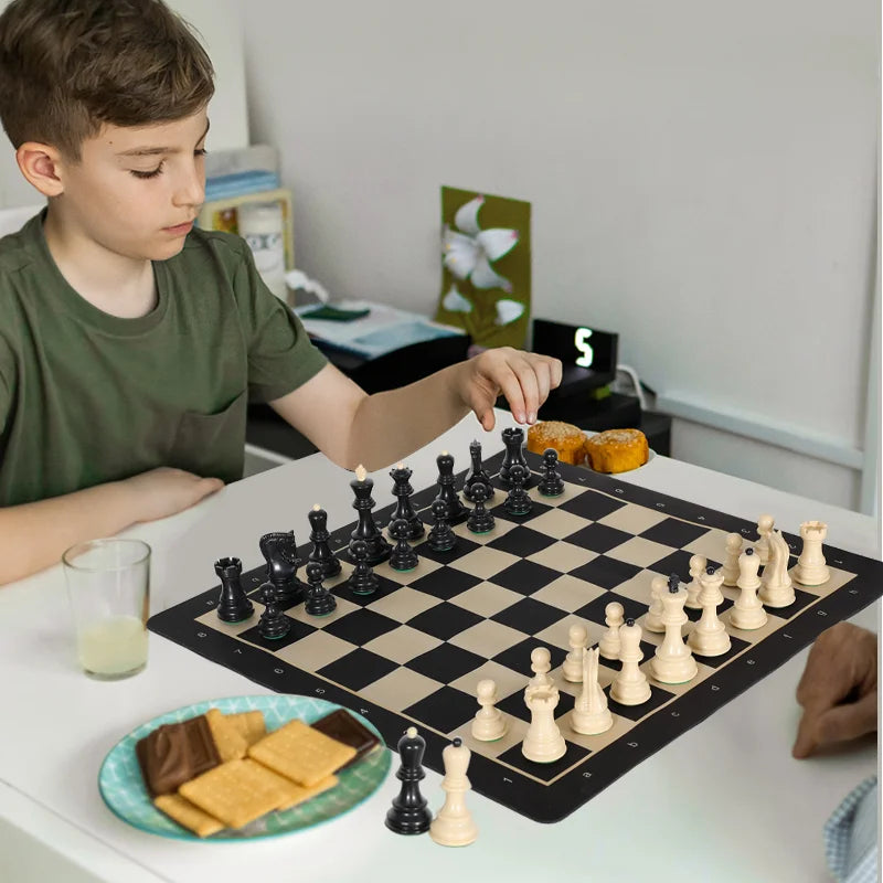 A wooden portable folding chess set with weighted black and white pieces is displayed on a white table.