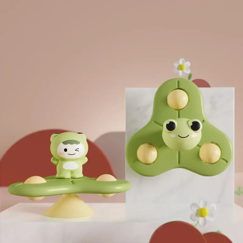A green suction cup spinner bath toy shaped like a crocodile is displayed on a white surface.