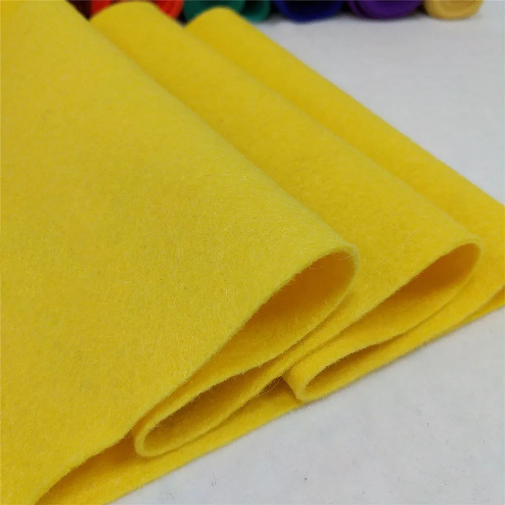 Yellow felt fabric sheets rolled and stacked for DIY crafts and sewing projects