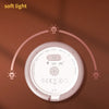 A round, pink night light shaped like a coffee cup, emitting soft light, shown against a brown background.