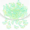 A pile of light green butterfly glass beads for jewelry making