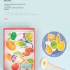 A red box containing various colorful food-themed domino patterns and a wooden bear feeding game toy.