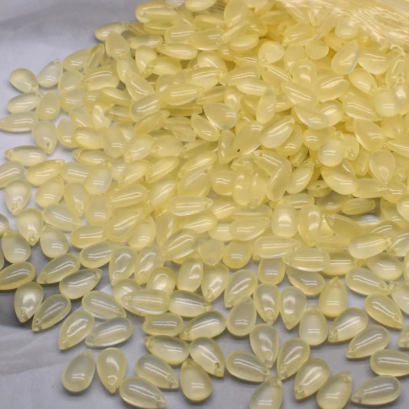 A pile of translucent yellow water drop Czech glass beads for jewelry making