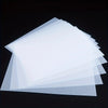 A stack of translucent white A4 DTF transfer film sheets for custom printing