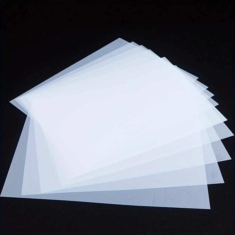 A stack of translucent white A4 DTF transfer film sheets for custom printing