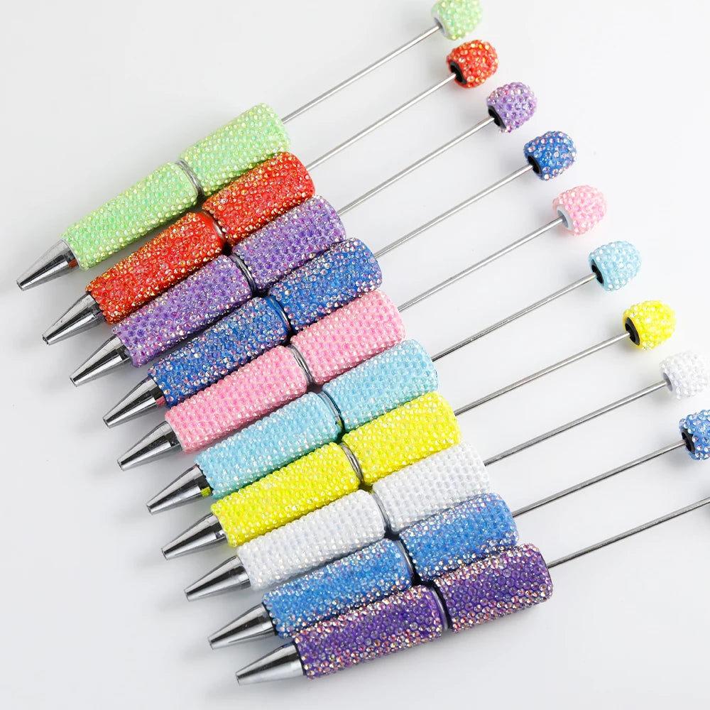 A collection of colorful rhinestone pen blanks for DIY jewelry making arranged in a diagonal line.