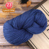 A skein of dark blue yarn is shown on a wooden surface, ready for knitting or weaving.