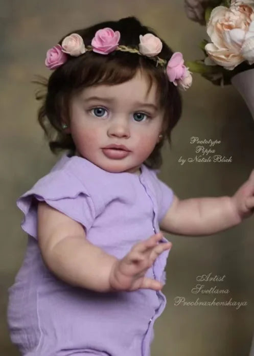 A baby doll kit featuring a lifelike reborn baby with painted vinyl parts and a floral headband.
