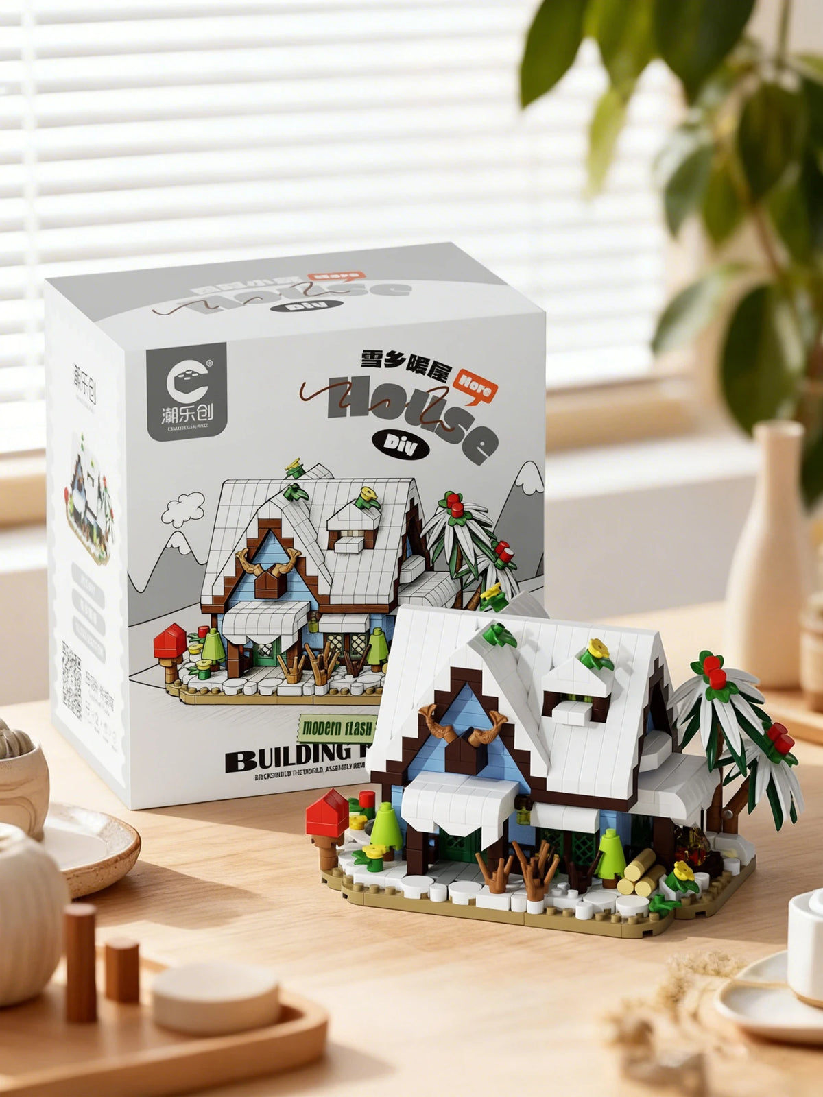 A box set of modern flash building blocks depicting a forest cabin with a greenhouse and windmill.