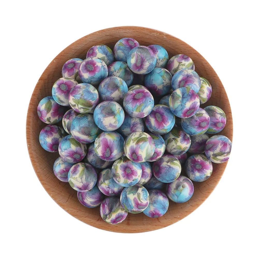 A pile of small, round silicone beads in shades of purple and blue resting in a wooden bowl.