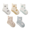 A set of five pairs of white and light-colored cartoon-themed non-slip socks for kids