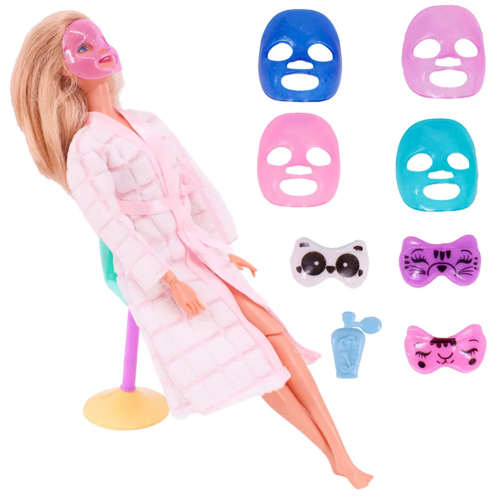 Poupée blonde portant un manteau rose et divers accessoires masques roses et bleus.