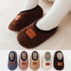A row of cozy plush baby slippers in various colors including gray, pink, beige, and brown.