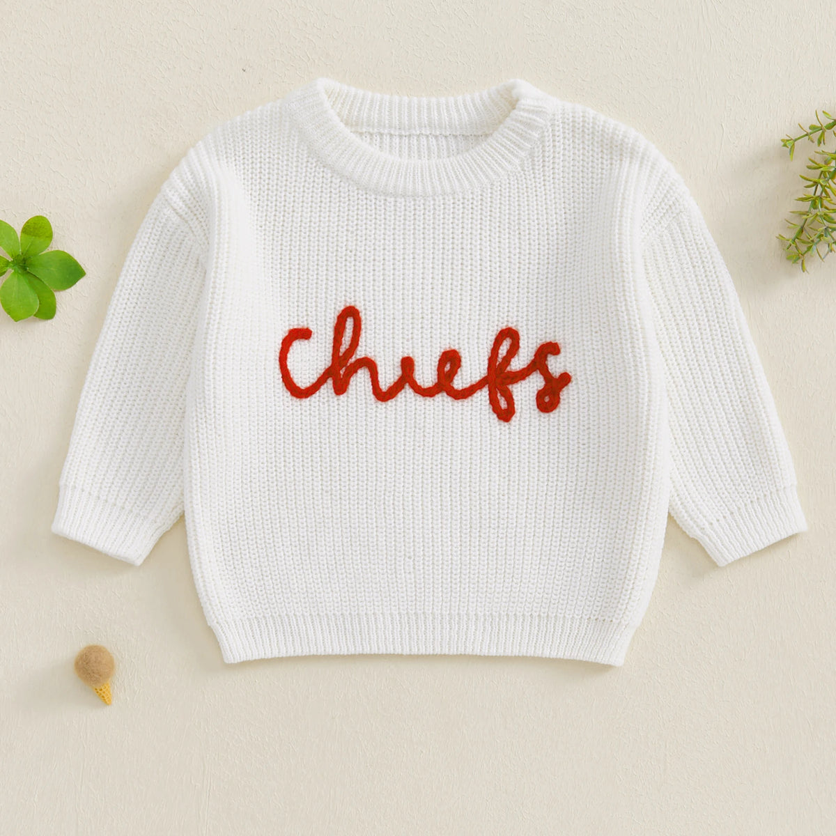 White knit sweater for kids with red embroidery spelling out chiefs