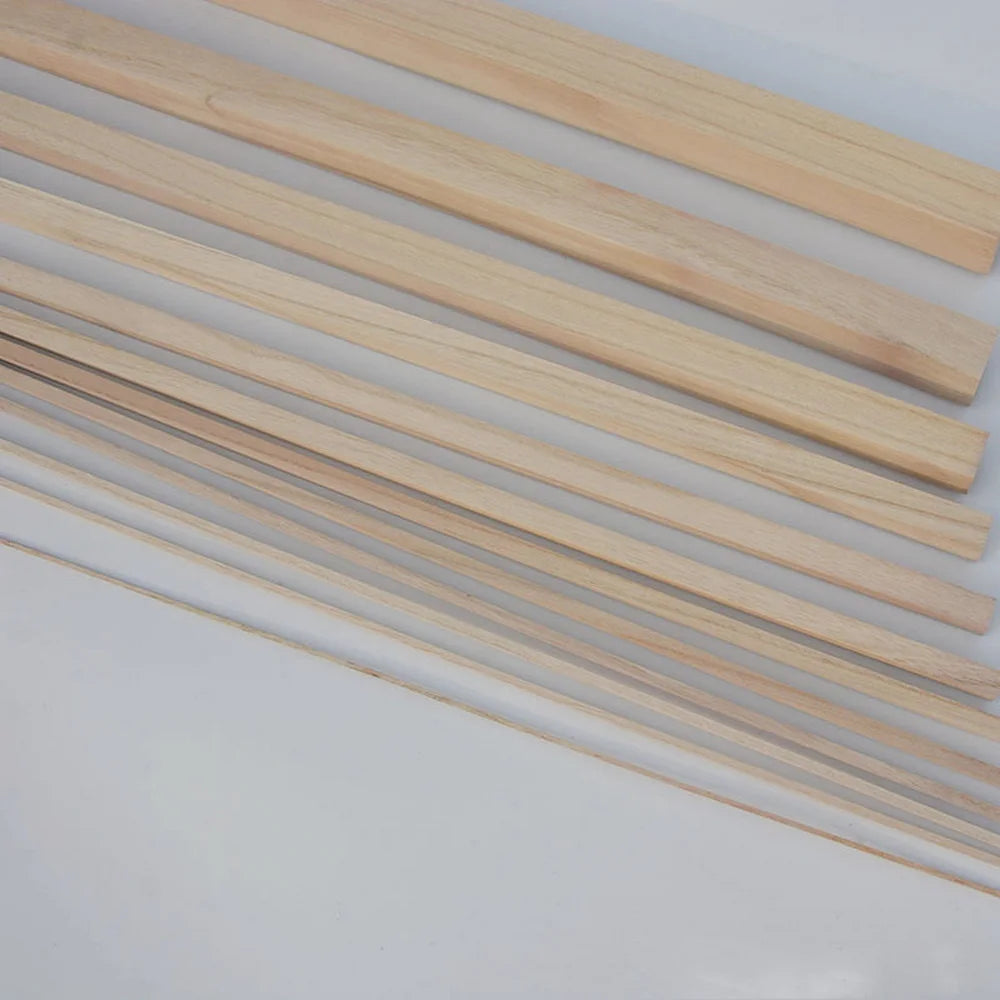 A collection of thin, light-colored natural solid wood strips laid diagonally on a white surface.