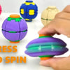 A hand is spinning a purple fidget spinner ball next to other colored balls on a white surface.