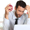 A man holds a pink brain-shaped stress relief ball while looking stressed near a laptop.