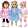Three dolls wearing pink and blue winter outfits including coats, dresses, and boots