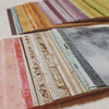 A close-up view of a pack of rainbow textured paper strips in various colors and shades.