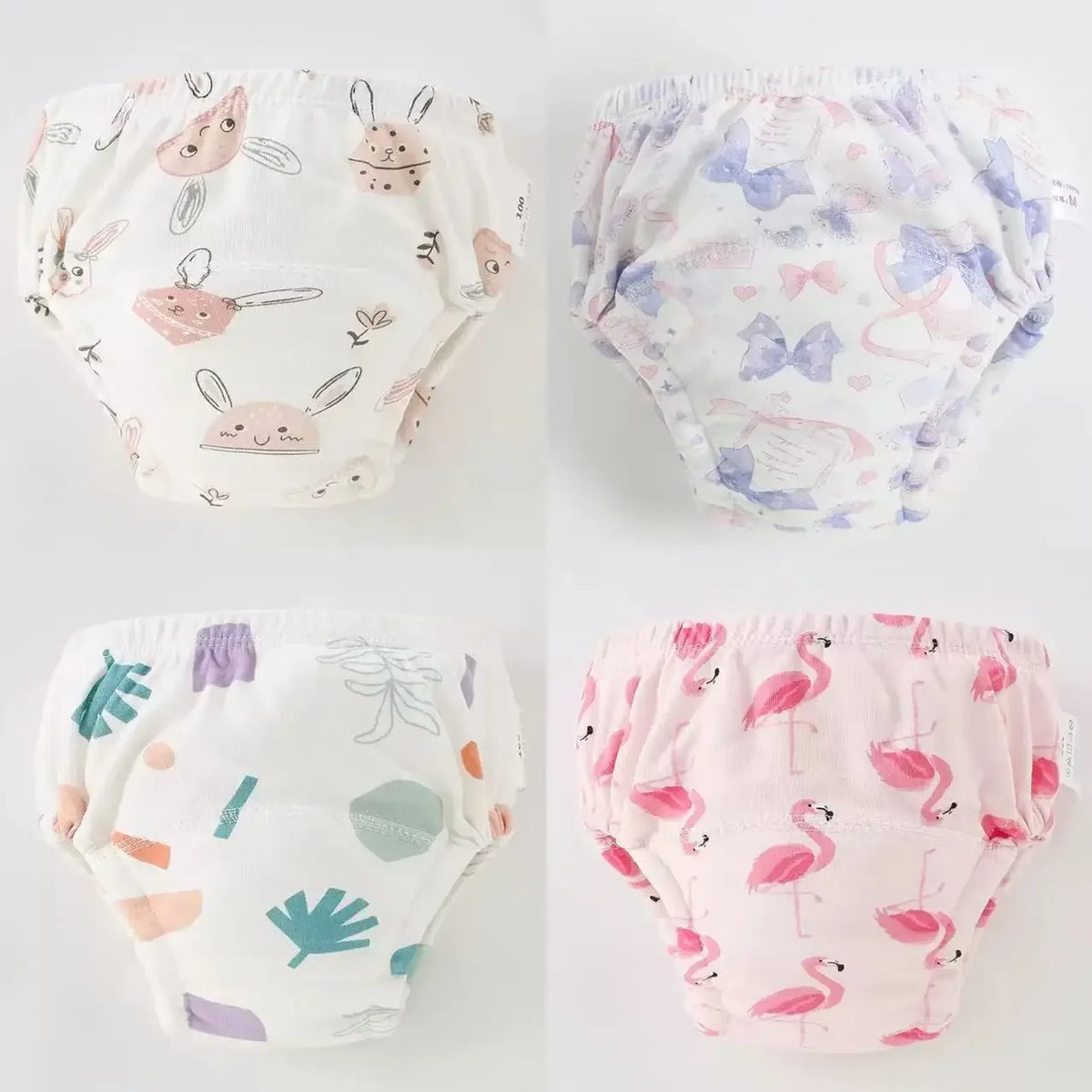 A set of four reusable cotton potty training pants for toddlers in various pastel patterns.