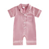 A pink satin button-up romper sleepwear for toddlers with a collar and patch pocket.