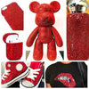A collection of red resin rhinestones and finished craft items including a bear figure, a pouch, and a shoe.