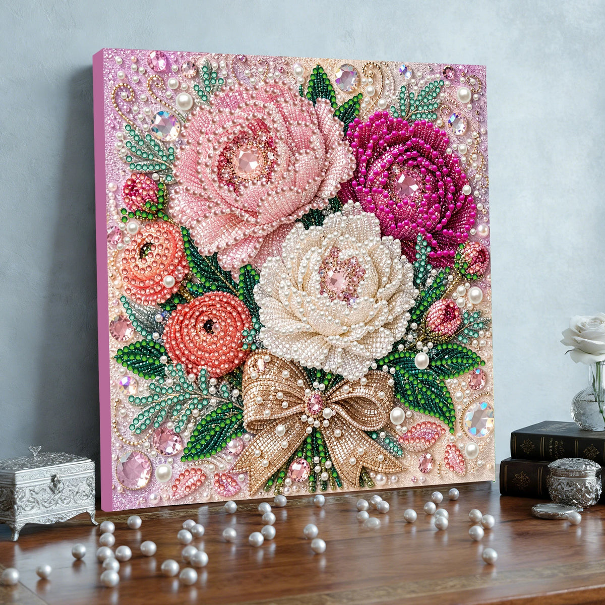 A vibrant floral painting kit featuring pink and purple roses on a wooden frame with various tools and pearls.
