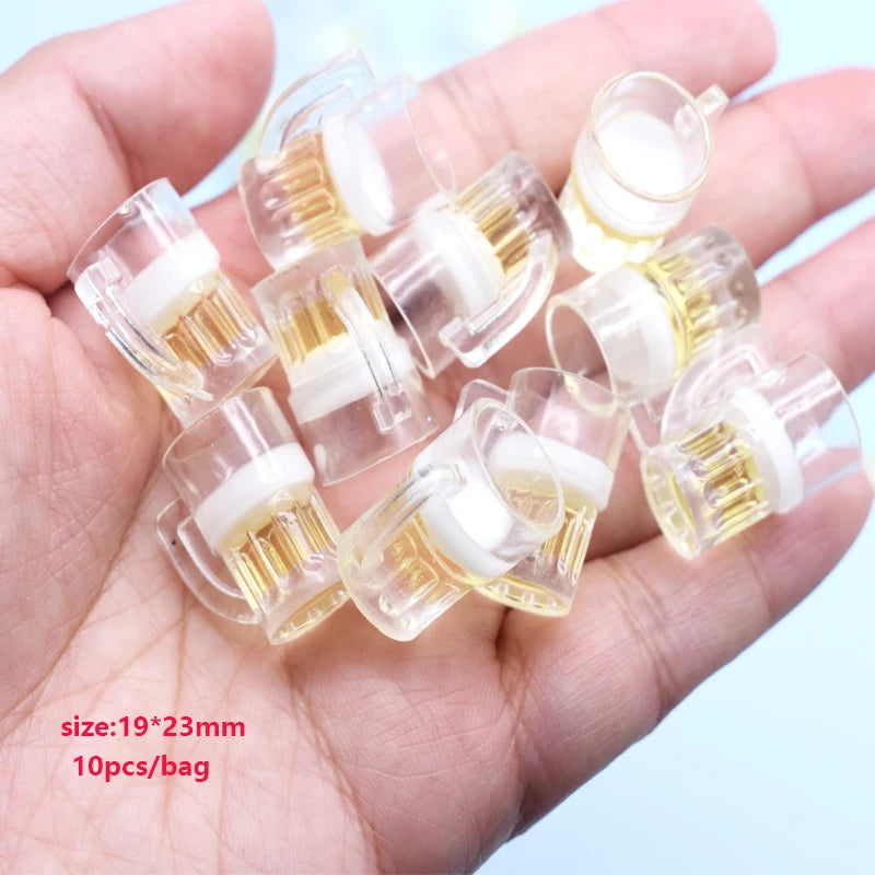 A hand holds several small clear plastic charms with yellow sunflower elements for jewelry making