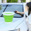 A person is holding a lime green collapsible bucket with a lid, placing it on the hood of a white car.